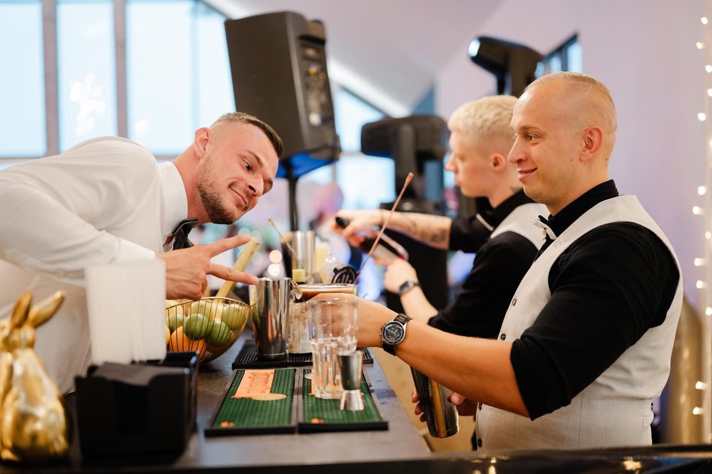 Trzech barmanów pracujących przy barze