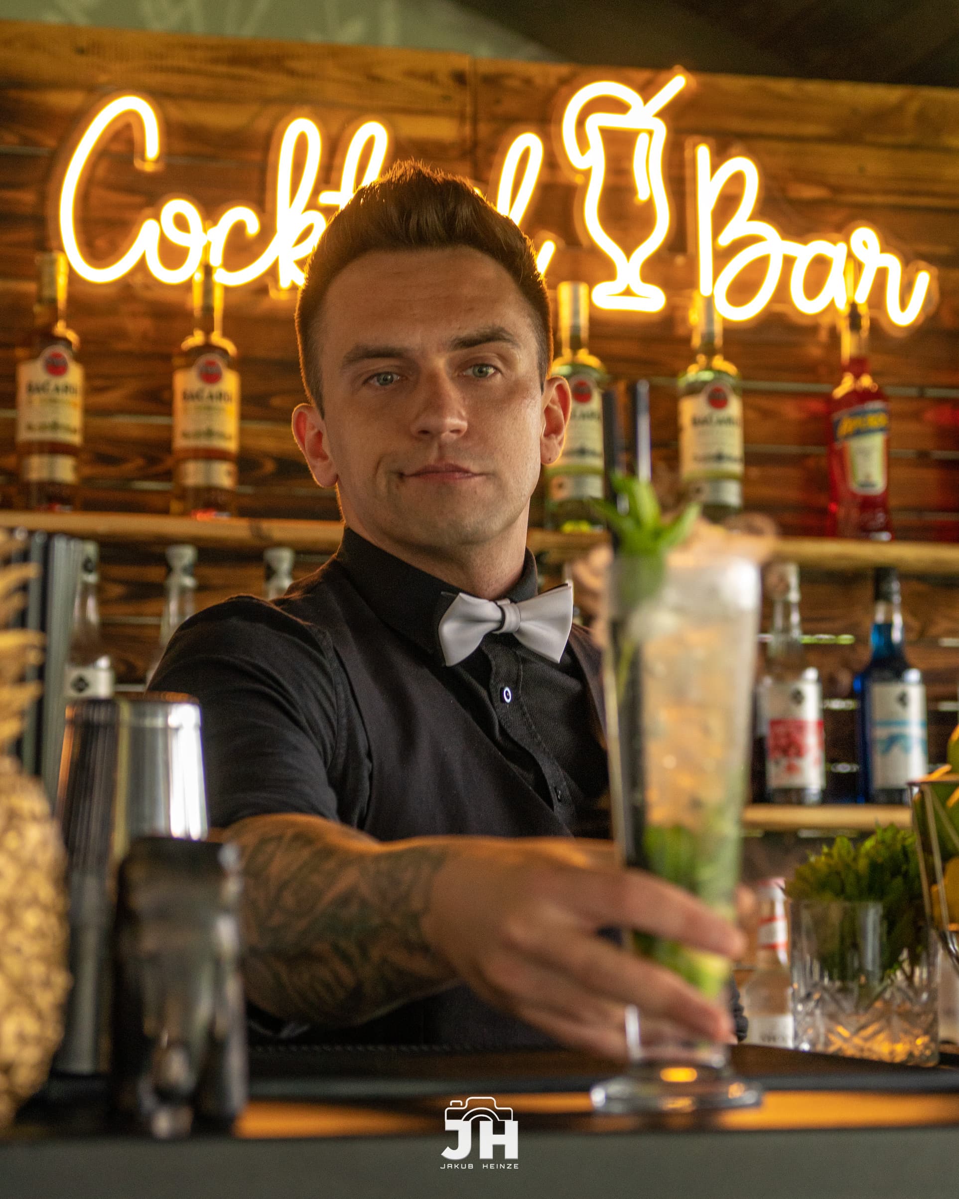 Barman serwuje cocktail przy barze drewnianym
